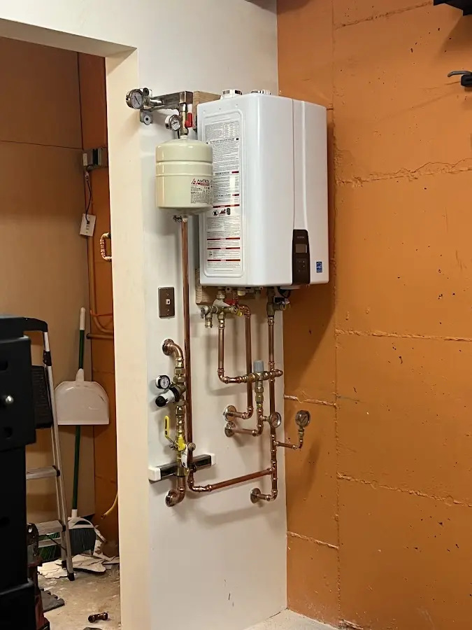 Plumbing technician inspecting water heater connections in Stow